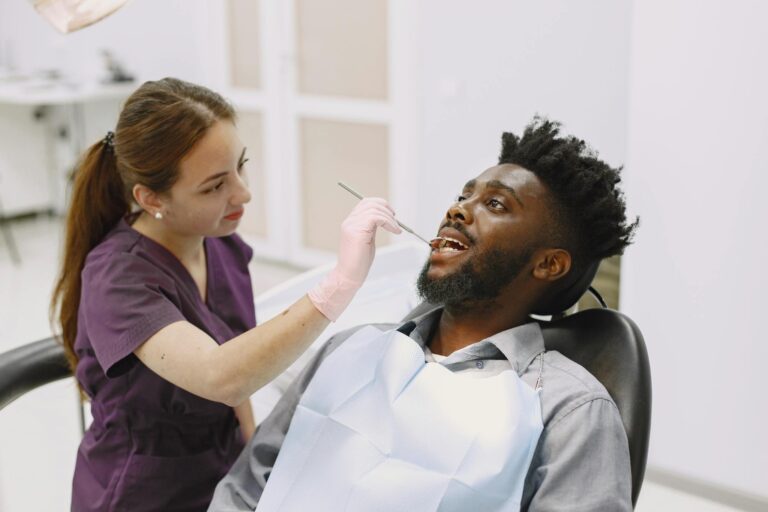Female dentist examining a male patient in a modern dental clinic. Healthcare professionalism.